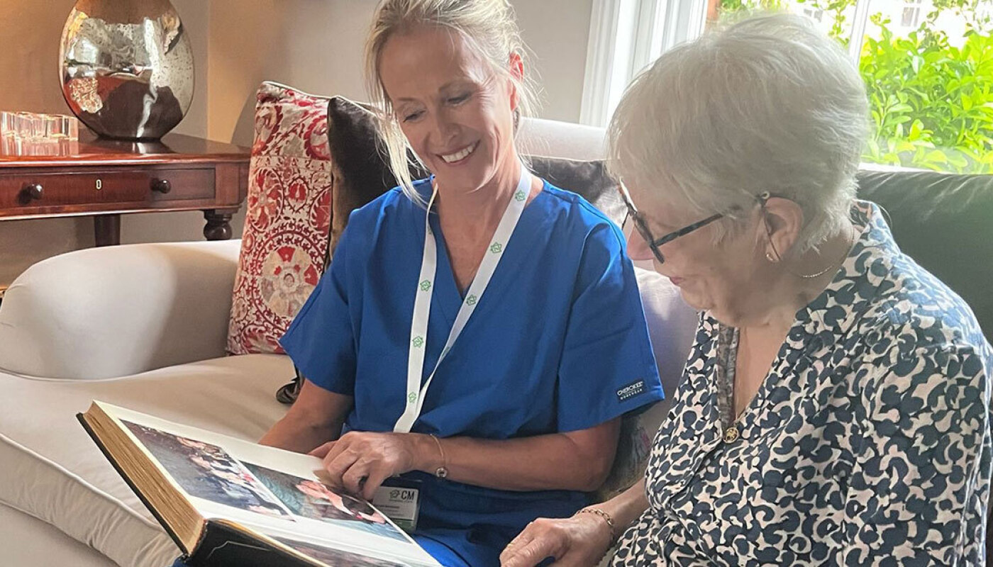 CM Bespoke Care worker with eldery person looking at photo album