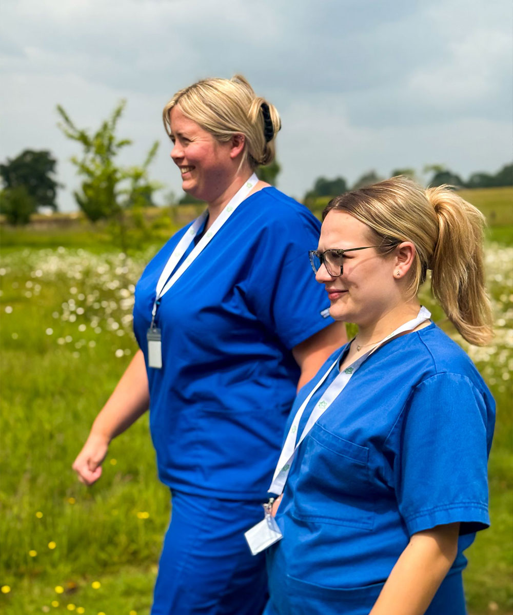 Two CM Bespoke Care workers walking outdoors
