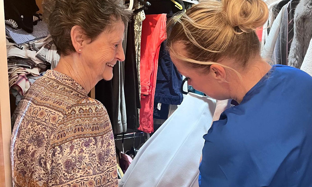 Two women choosing clothes from a wardrobe
