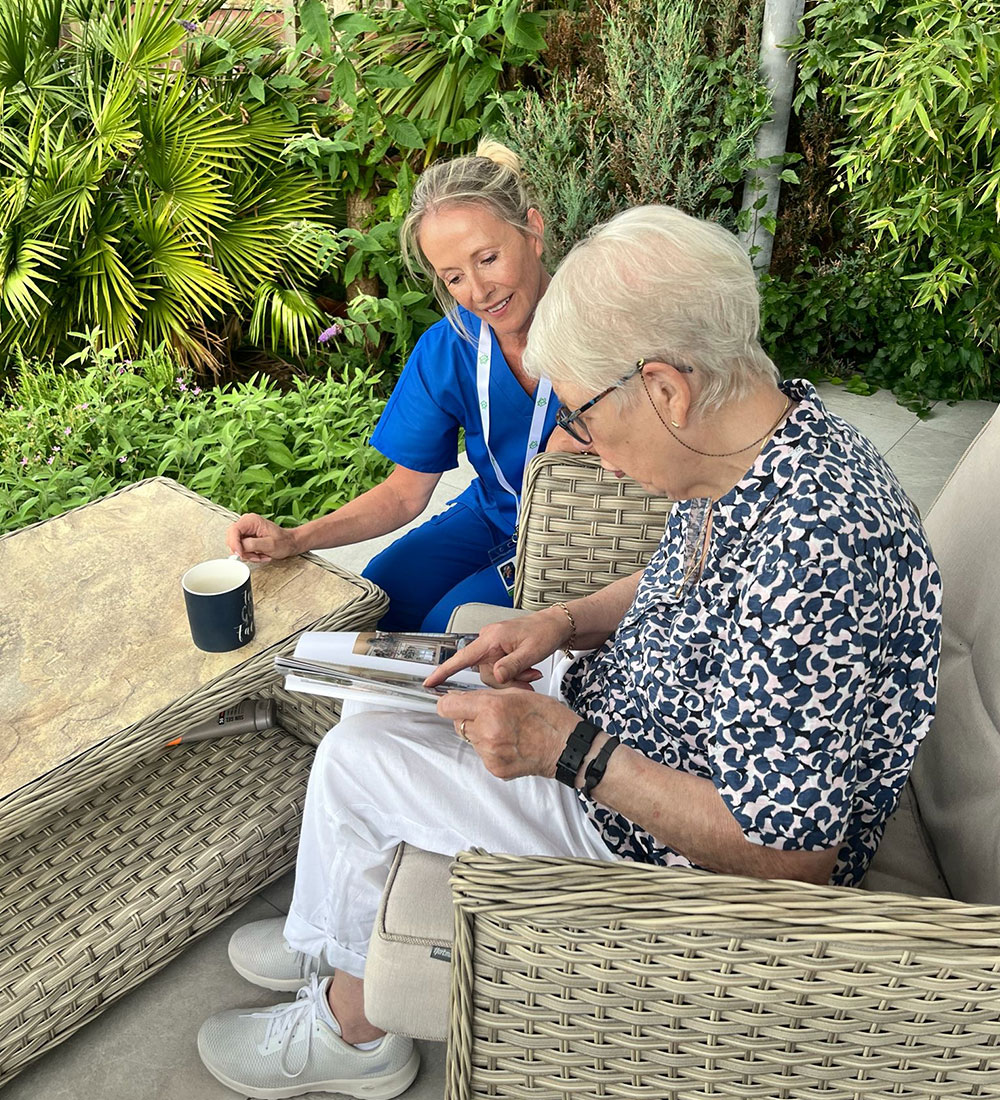Two women enjoying coffee and chat outside